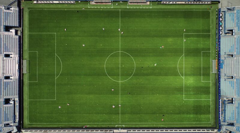 Aerial view of a floodlit football stadium and pitch, illustrating the summer 2026 Premier League transfer window